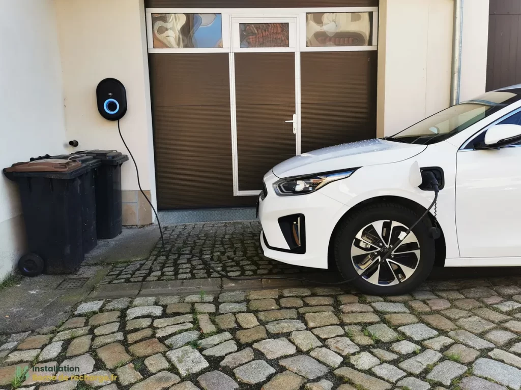 Une voiture électrique branchée à une borne de recharge installée à domicile.