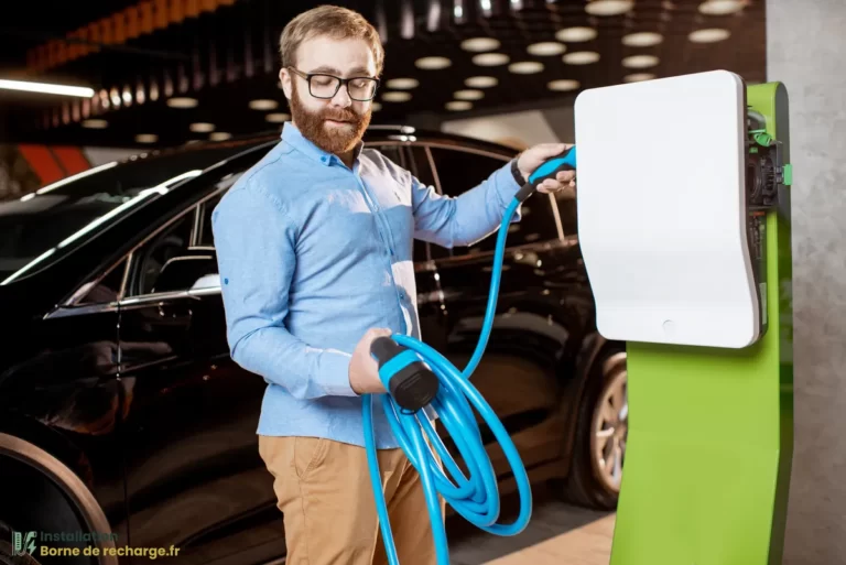 Un homme utilise une borne de recharge pour voiture électrique.